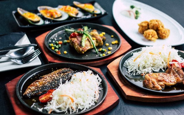 Rangée de pintxos variés sur un comptoir de bar basque, verres de vin
