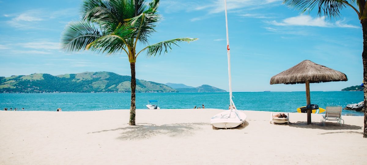 Petit village côtier basque avec maisons blanches et volets verts, mer bleue