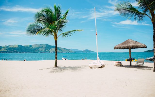 Petit village côtier basque avec maisons blanches et volets verts, mer bleue